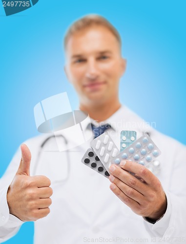 Image of male doctor with packs of pills