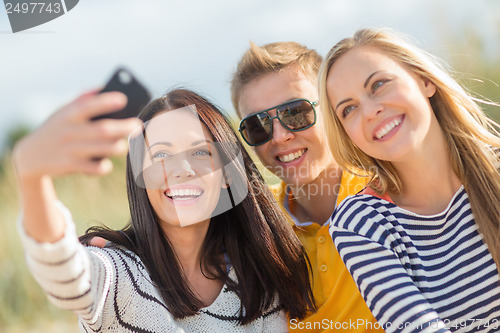 Image of group of friends taking picture with smartphone