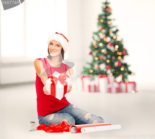 Image of smiling woman in santa helper hat with gift box