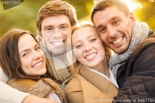 Image of group of friends having fun in autumn park