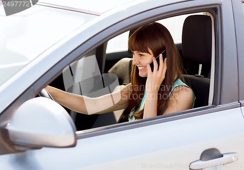 Image of woman using phone while driving the car