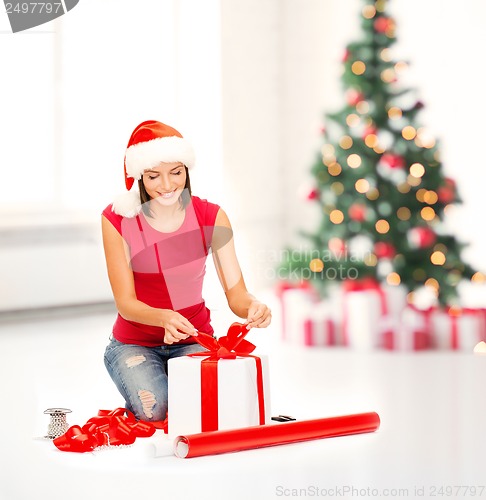 Image of smiling woman in santa helper hat with gift box