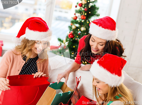 Image of women in santa helper hats with shopping bags