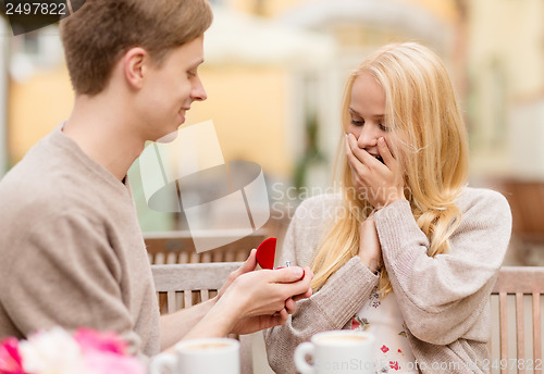 Image of romantic man proposing to beautiful woman