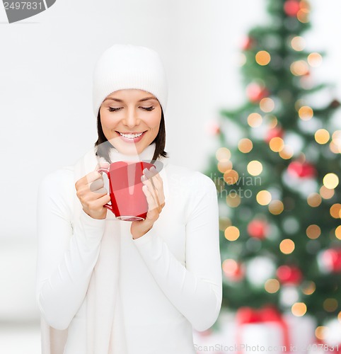 Image of woman in hat with red tea or coffee mug