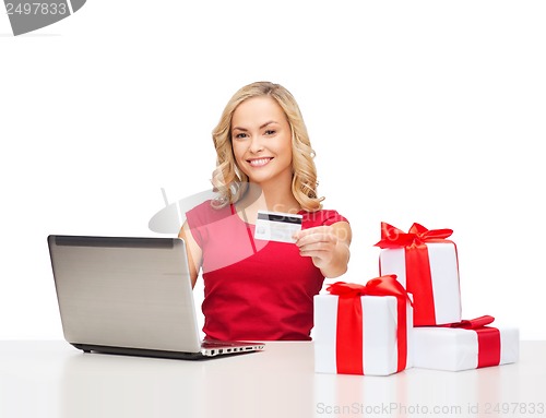 Image of woman with gifts, laptop computer and credit card