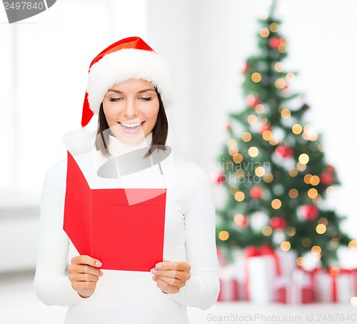 Image of woman in santa helper hat with blank red postcard