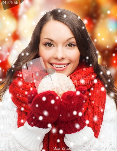 Image of woman in scarf and mittens with christmas ball