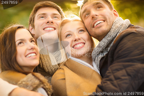 Image of group of friends having fun in autumn park