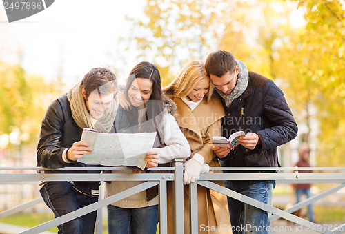 Image of couples with tourist map in autumn park