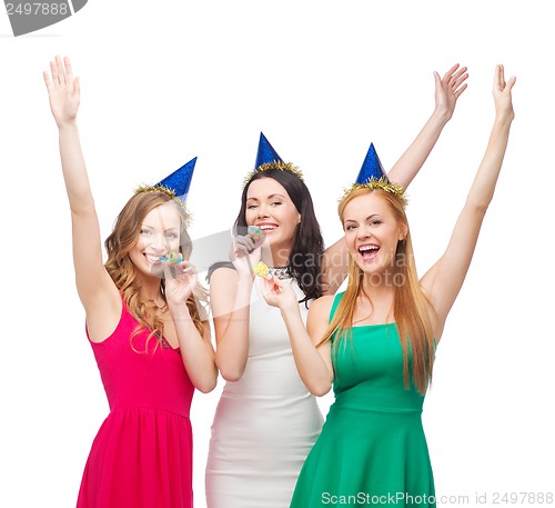 Image of three smiling women in hats blowing favor horns