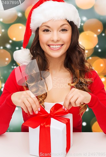 Image of smiling woman in santa helper hat with gift box