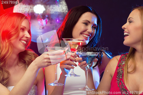 Image of three smiling women with cocktails and disco ball