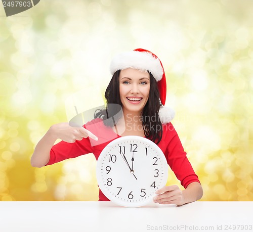 Image of woman in santa helper hat with clock showing 12