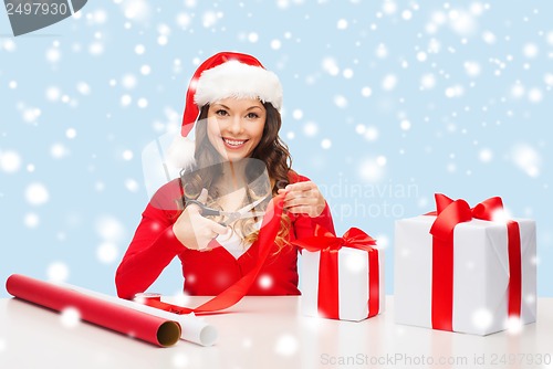 Image of smiling woman in santa helper hat with gift box