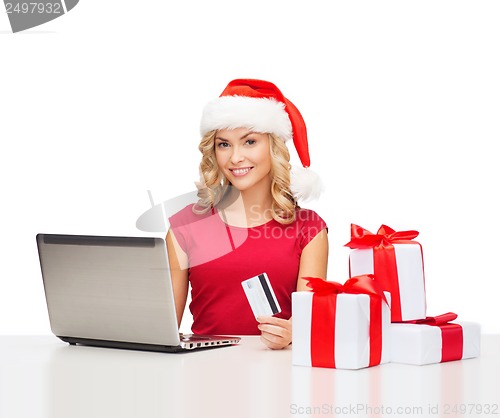 Image of woman with gifts, laptop computer and credit card