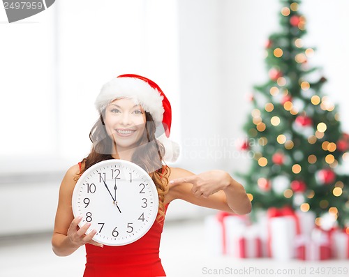 Image of woman in santa helper hat with clock showing 12