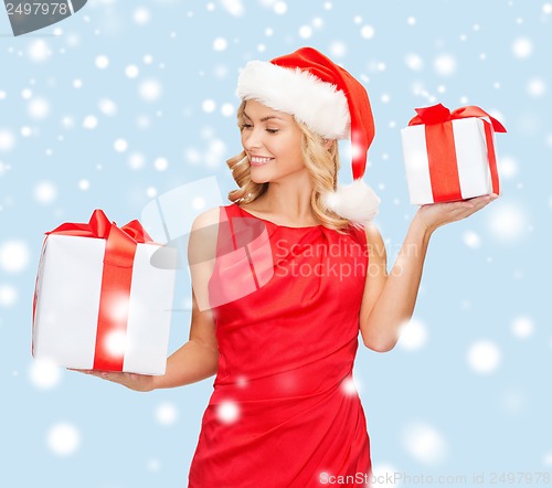 Image of woman in santa helper hat with many gift boxes