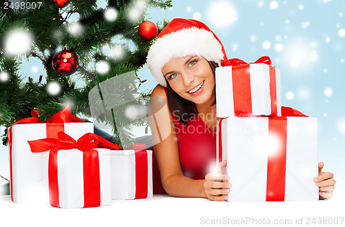 Image of smiling woman in santa helper hat with gift boxes
