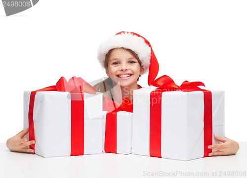 Image of girl in santa helper hat with many gift boxes