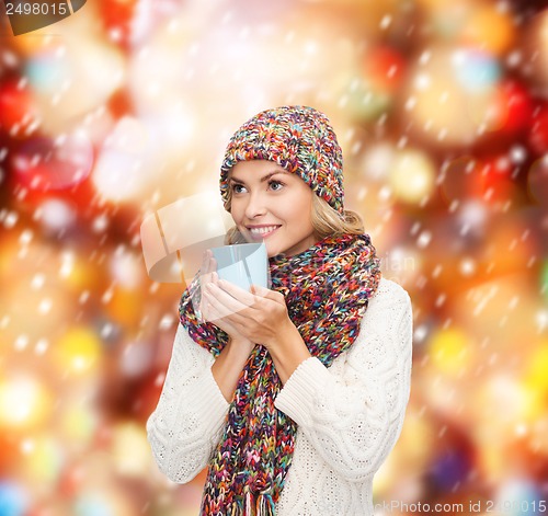 Image of woman in hat with red tea or coffee mug