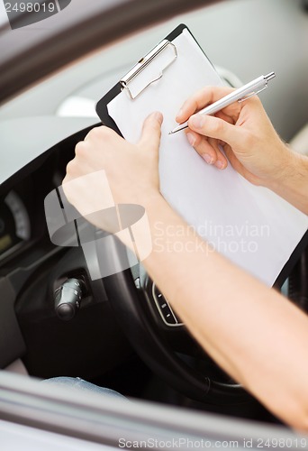 Image of man with car documents