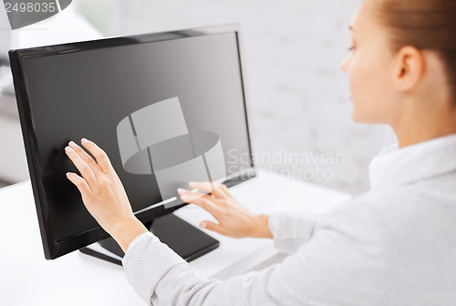 Image of smiling businesswoman with touchscreen in office