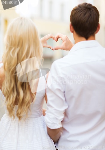 Image of romantic couple in the city making heart shape