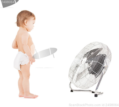 Image of cute little boy playing with big cooling fan