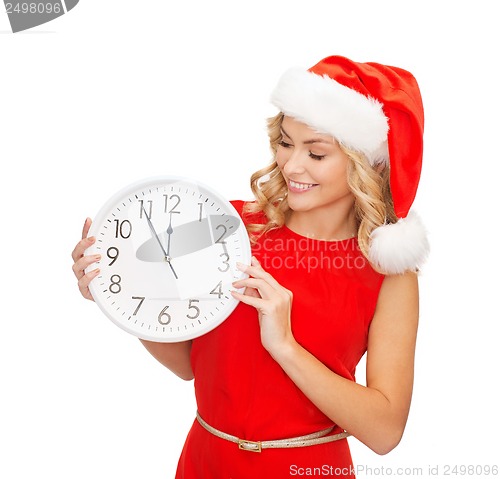 Image of woman in santa helper hat with clock showing 12