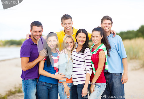 Image of group of friends having fun on the beach