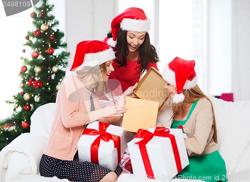 Image of women in santa helper hats with many gift boxes