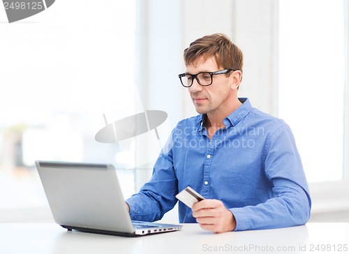 Image of man with laptop and credit card at home