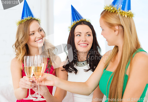 Image of three women wearing hats with champagne glasses