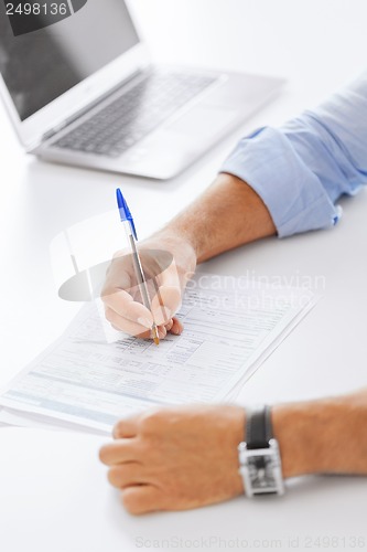 Image of man signing a contract