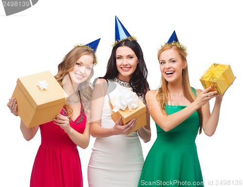 Image of three smiling women in blue hats with gift boxes