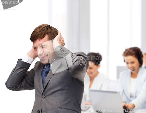 Image of stressed buisnessman or teacher closing ears