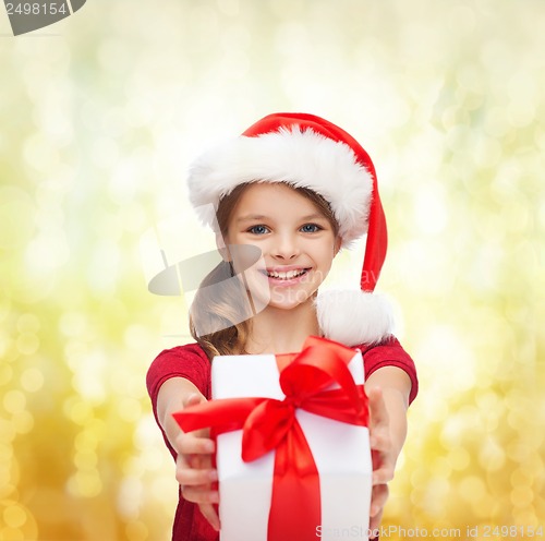 Image of smiling girl in santa helper hat with gift box