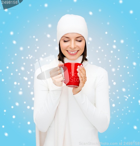 Image of woman in hat with red tea or coffee mug