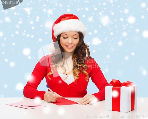 Image of smiling woman in santa helper hat with postcard