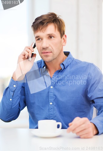 Image of buisnessman with cell phone and cup of coffee