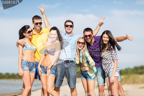 Image of group of friends having fun on the beach