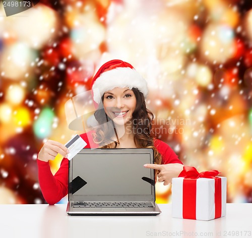 Image of woman with gift, laptop computer and credit card