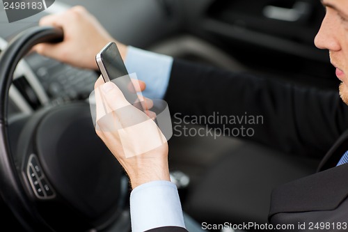 Image of man using phone while driving the car