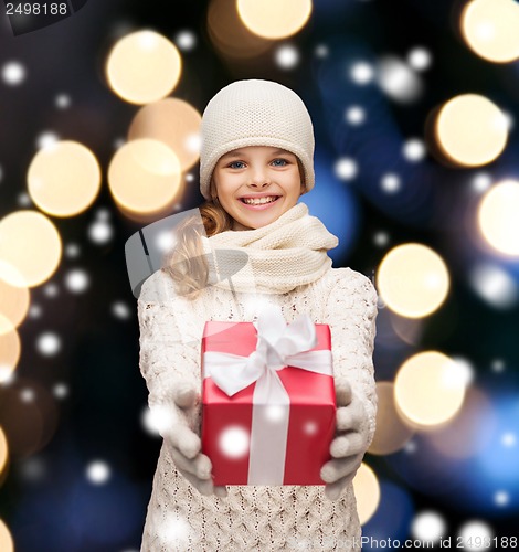 Image of girl in hat, muffler and gloves with gift box