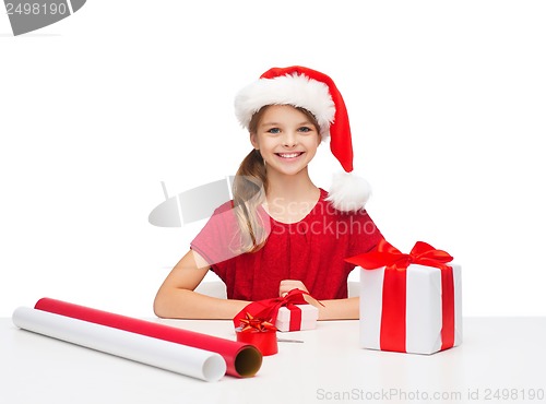 Image of smiling girl in santa helper hat with gift box