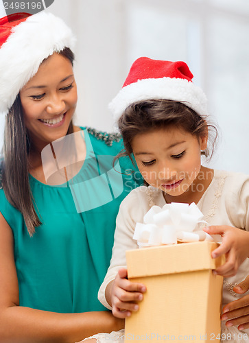 Image of happy mother and child girl with gift box