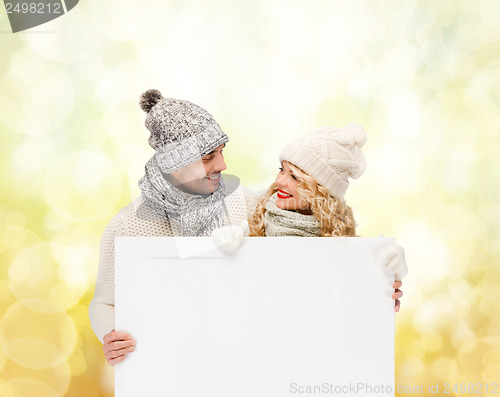 Image of couple in winter clothes with blank white board
