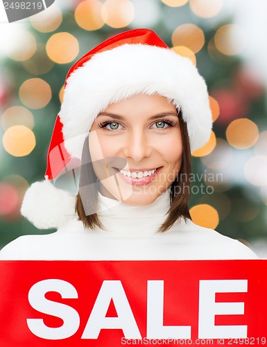 Image of woman in santa helper hat with red sale sign