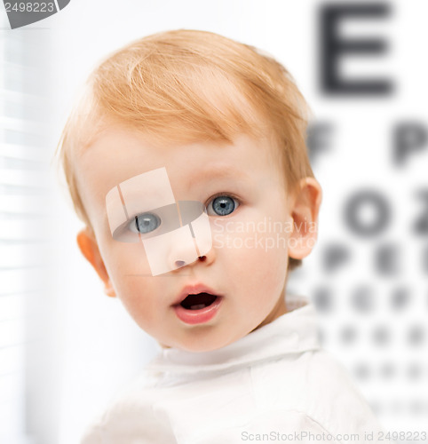 Image of adorable baby child with eyesight testing board